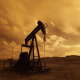 An oil pump in the desert at sunset.