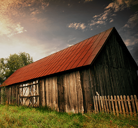 A wooden barn with a red roof.